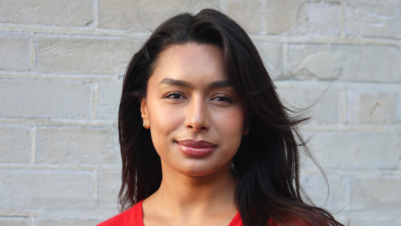 Sabrina Boudali, Distrkt’s new associate director, standing with her arms crossed against a brick wall