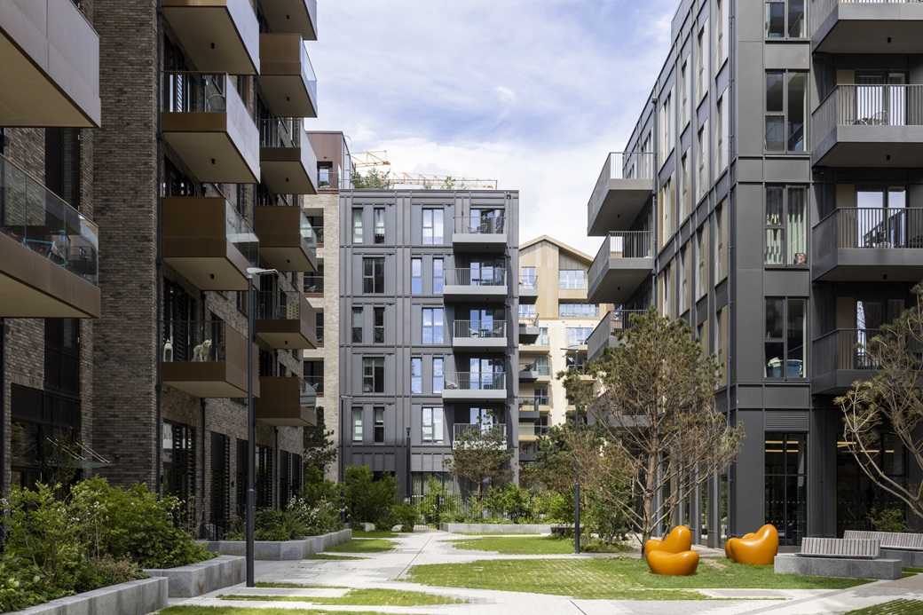 Landscaped courtyard between Quayside Quarter apartment buildings in Dublin’s North Docks, with orange sculptures
