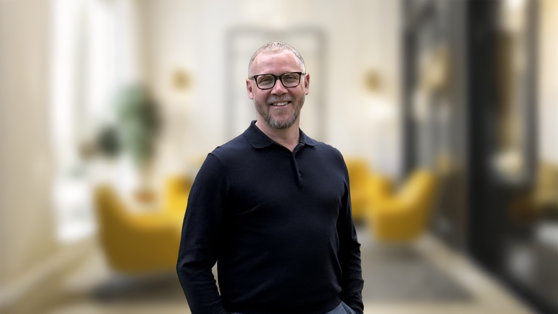 Iain Powis, Savills associate director, smiling in a black shirt in a blurred office