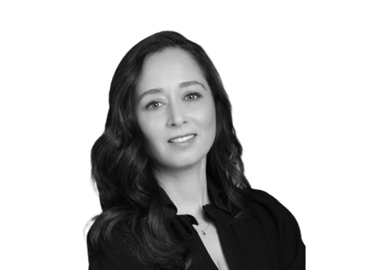 Black-and-white professional headshot of a woman with long dark hair wearing a black blouse