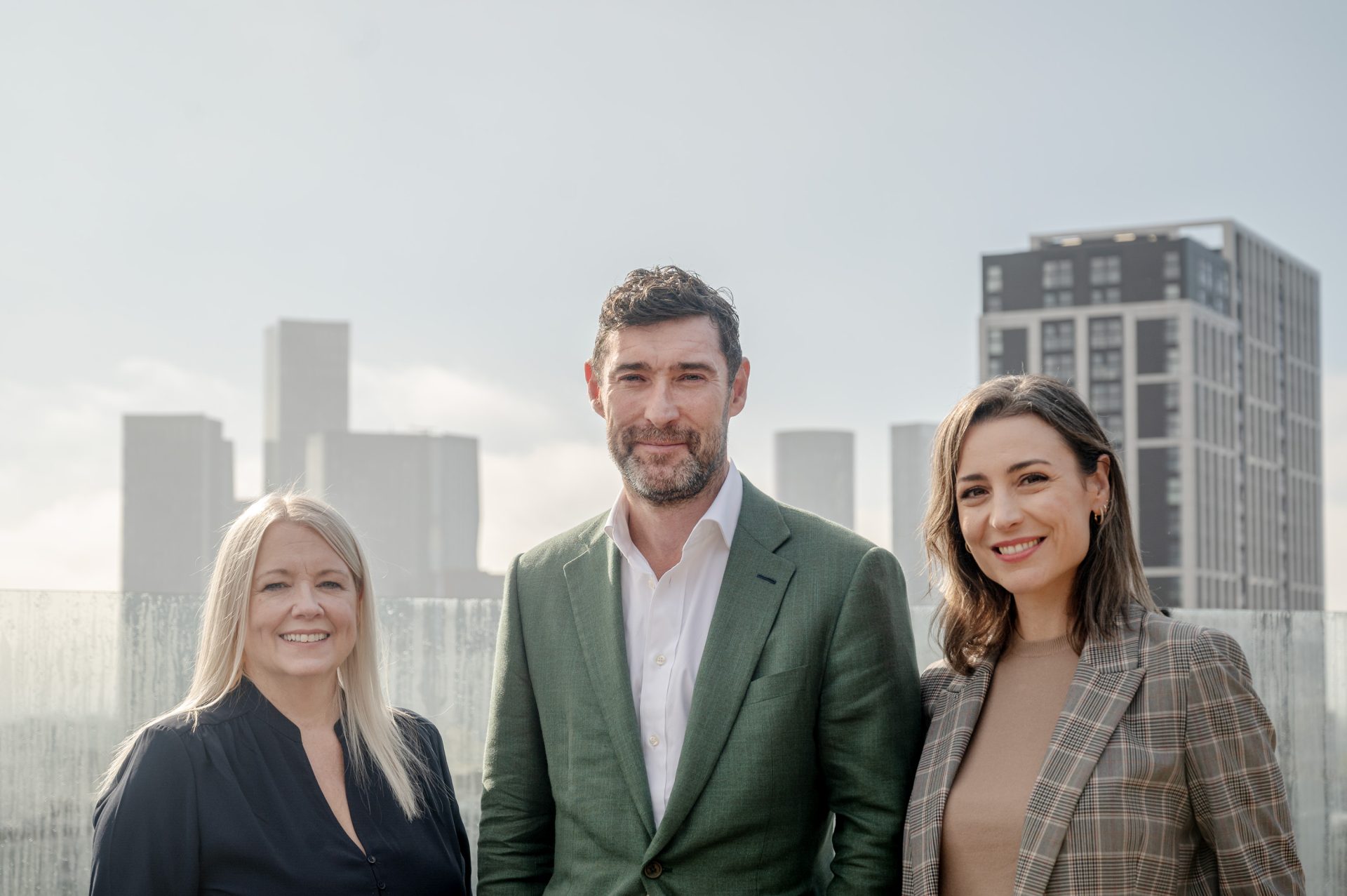 Three Leonard Curtis representatives, including CEO Dan Booth and Hilary Pascoe, stand in front of an office building.