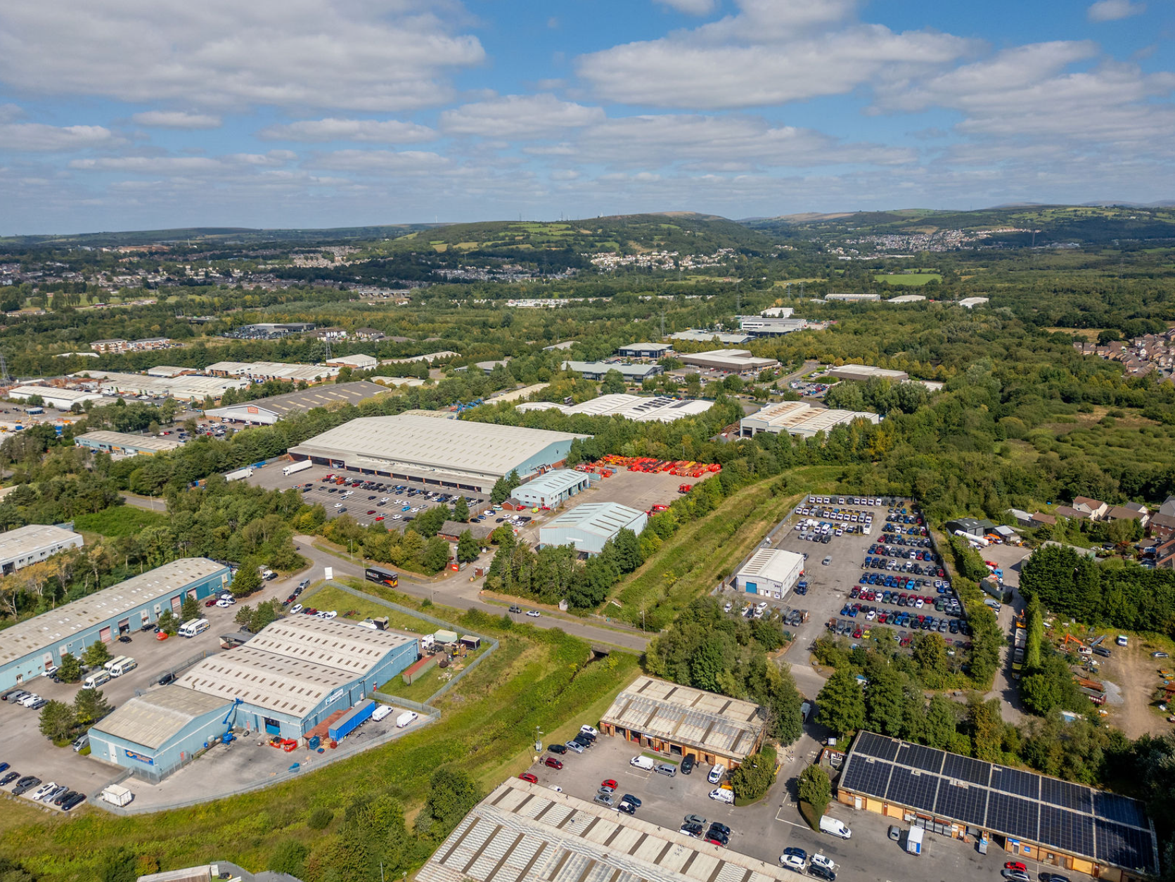 Aerial view of warehouses, industrial units and vehicle yards in a Welsh business park