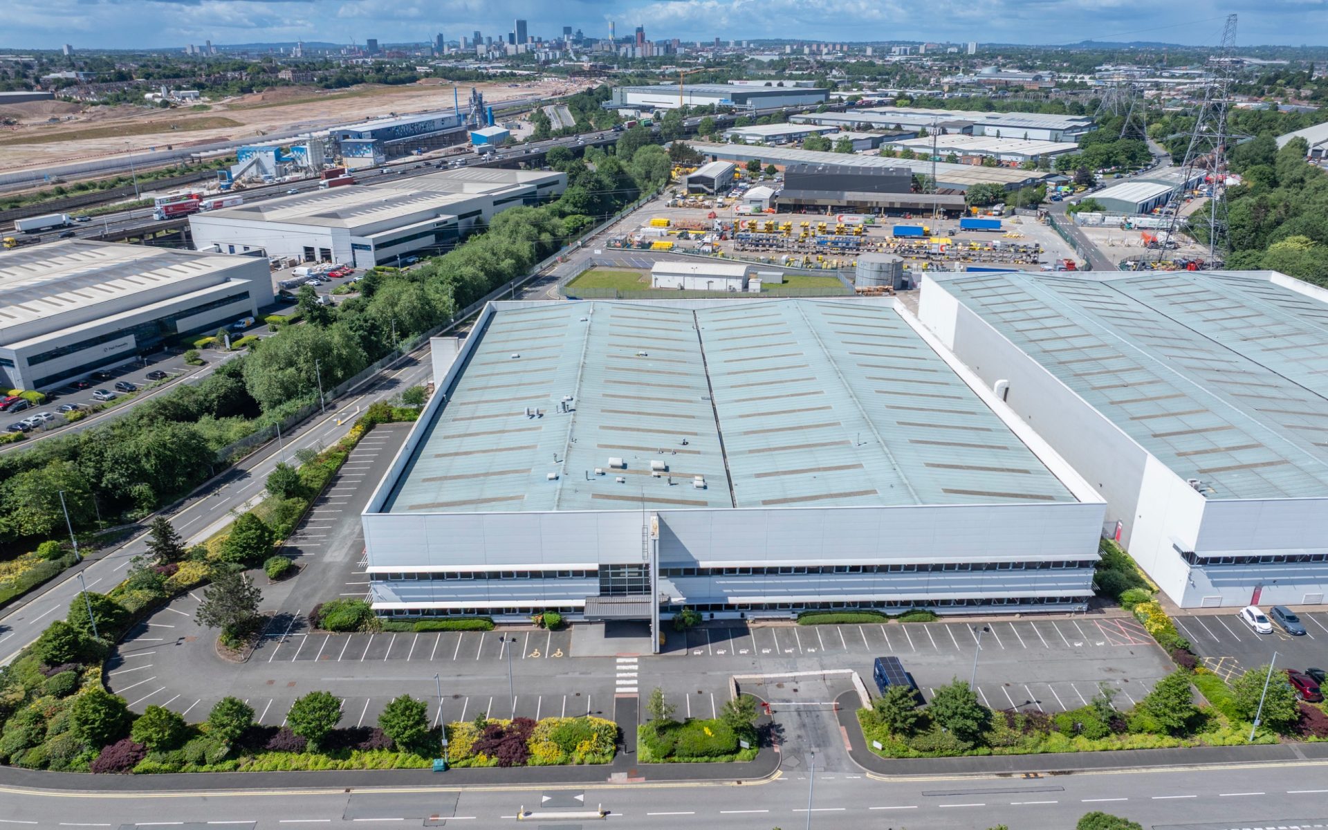 Aerial view of a large industrial warehouse and surrounding commercial property