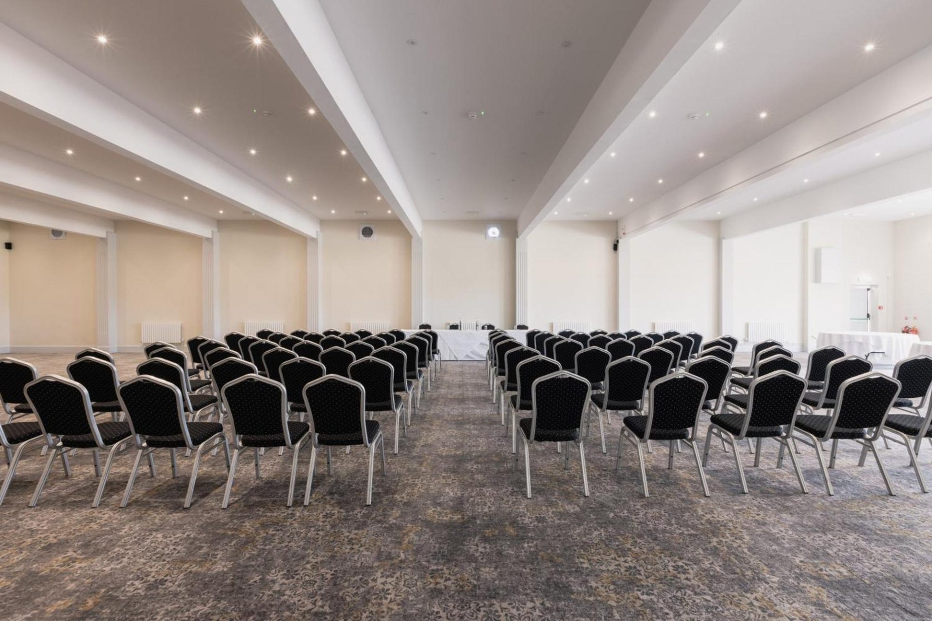 Empty conference room set with rows of chairs facing a presentation area.