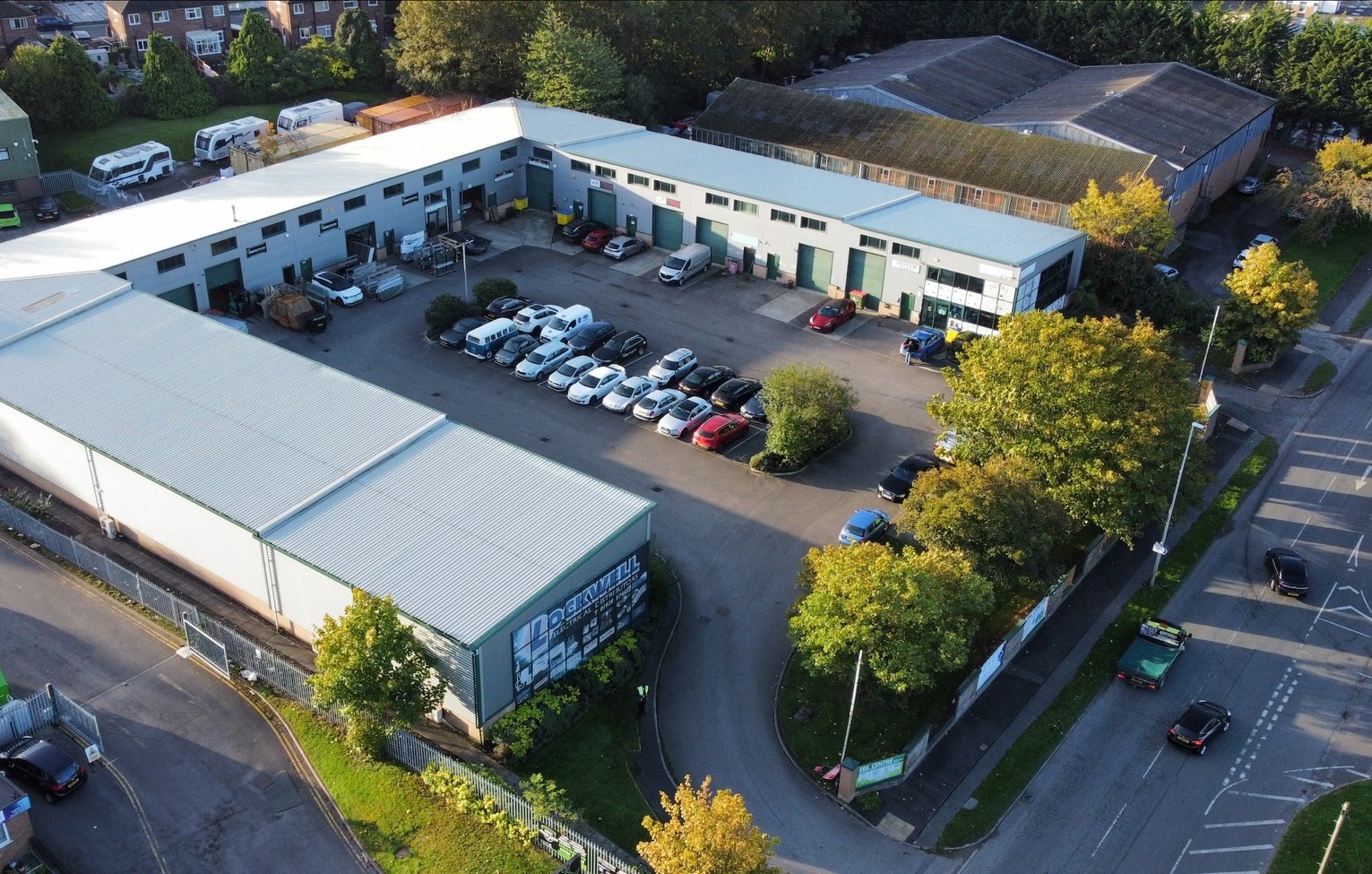 Aerial view of the EBL Centre industrial estate, with rows of units, parked cars and surrounding roads and trees.