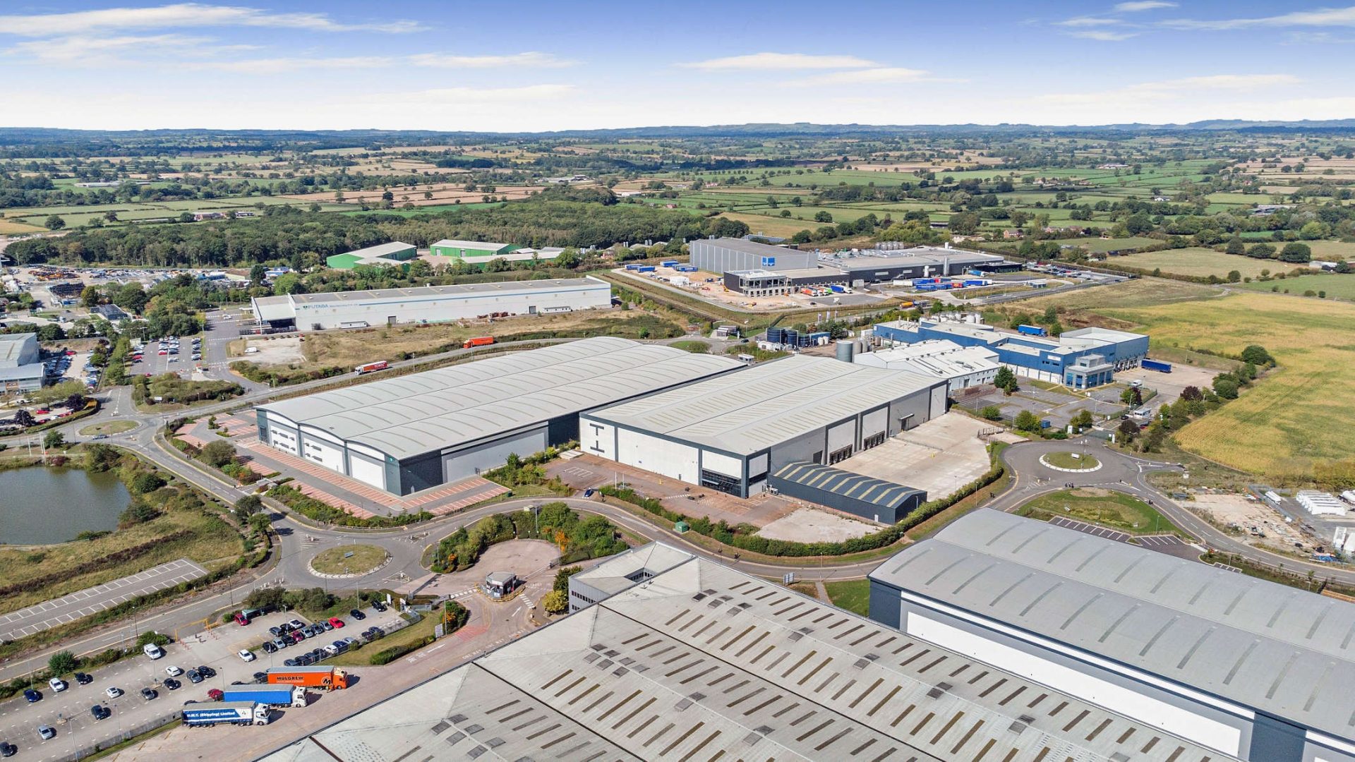 Aerial view of Indurent 129, a large warehouse at Dove Valley Park, surrounded by roads and fields.