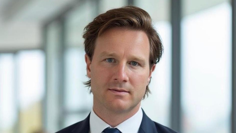 Portrait of Fraser Campbell-Wilson in a dark suit and tie.