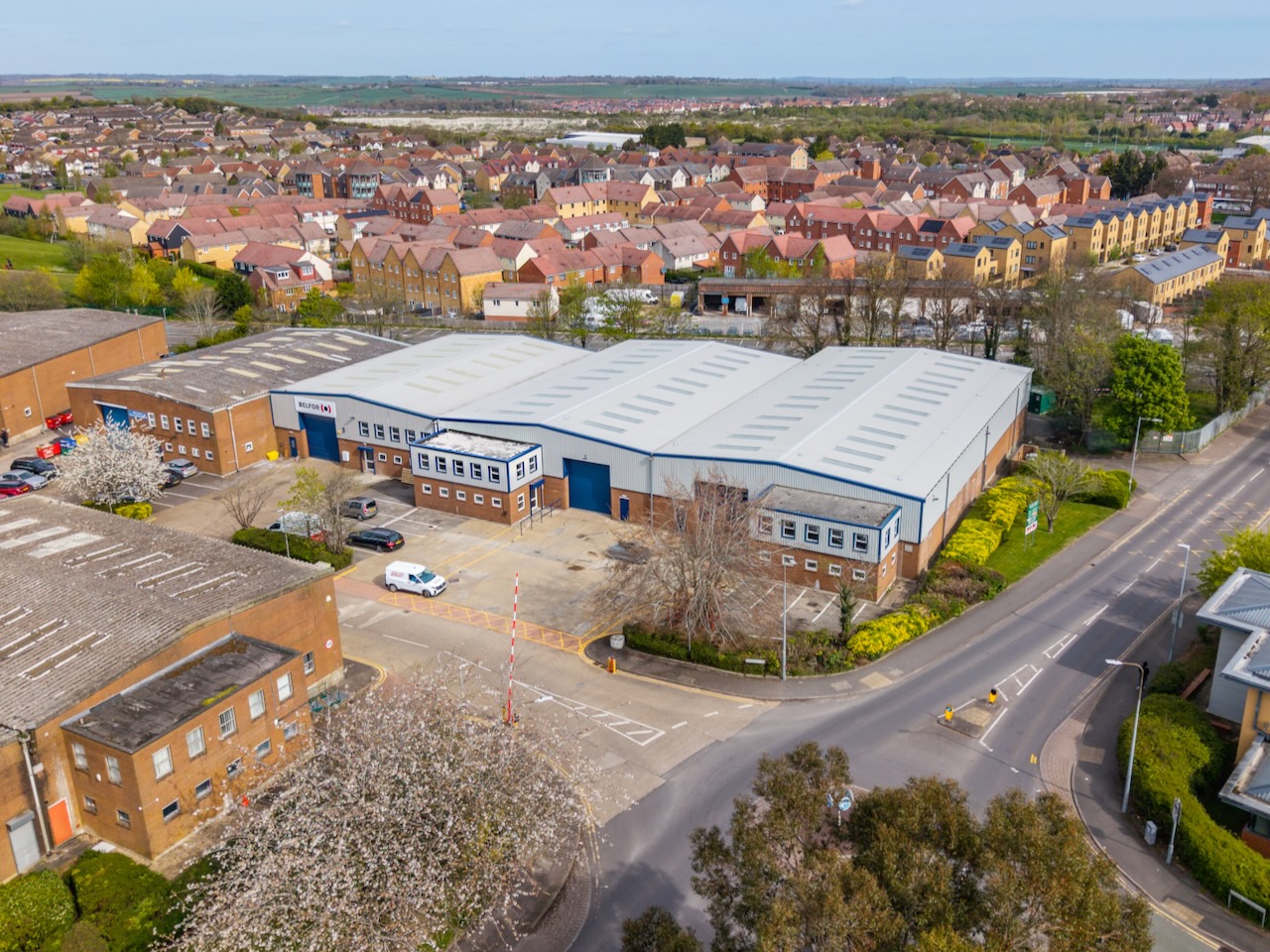 Aerial view of modern industrial units beside a road and residential neighbourhood