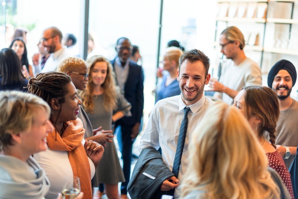A diverse group of professionals chat and mingle at a networking event.