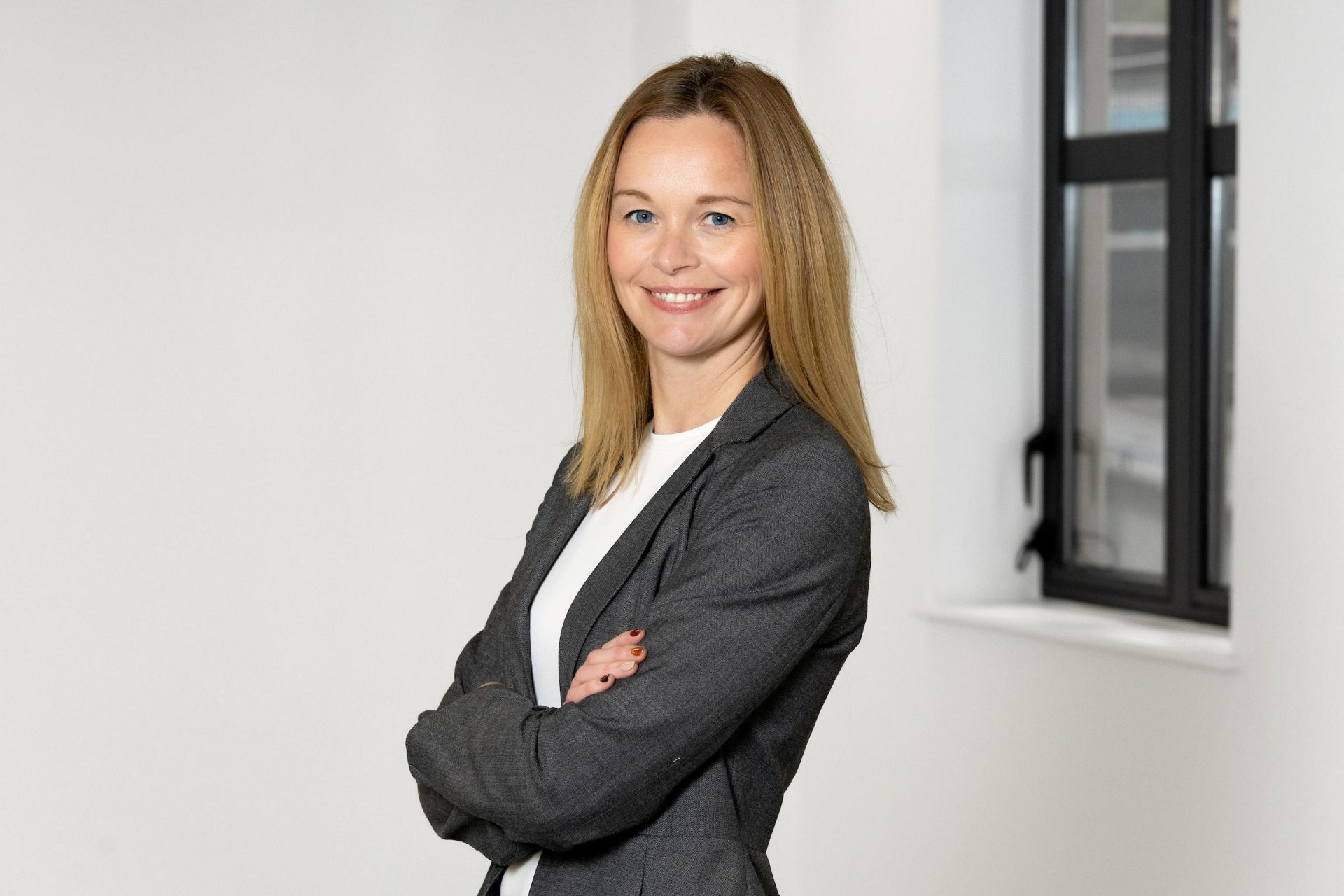 Real estate partner Rachel Kerr stands with her arms crossed in a dark blazer.