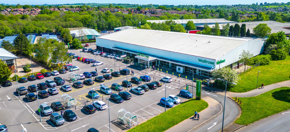 Aerial view of a Whitbread-branded commercial building and its large car park