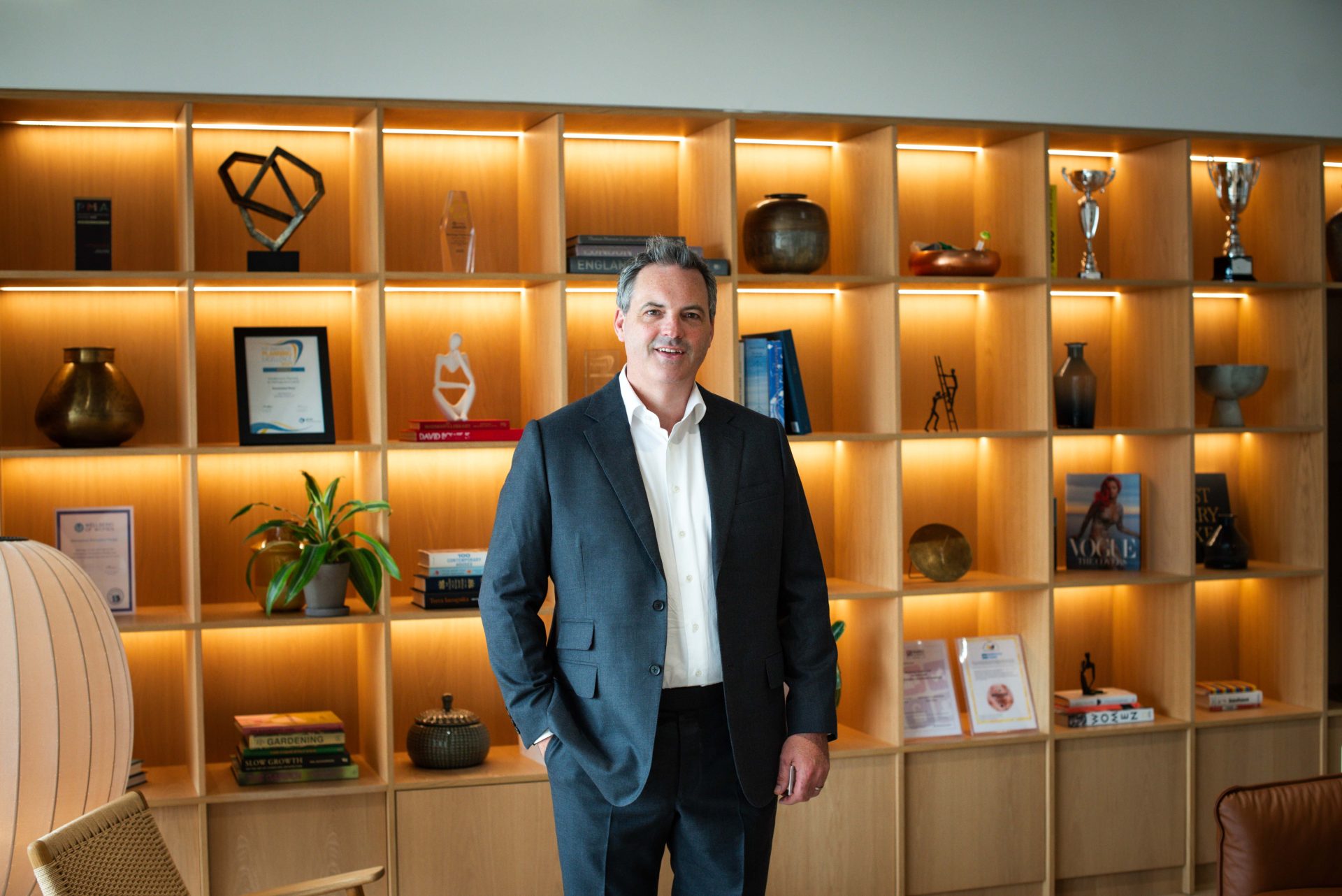 Montagu Evans managing partner Alan Harris stands in front of a display of office shelves.