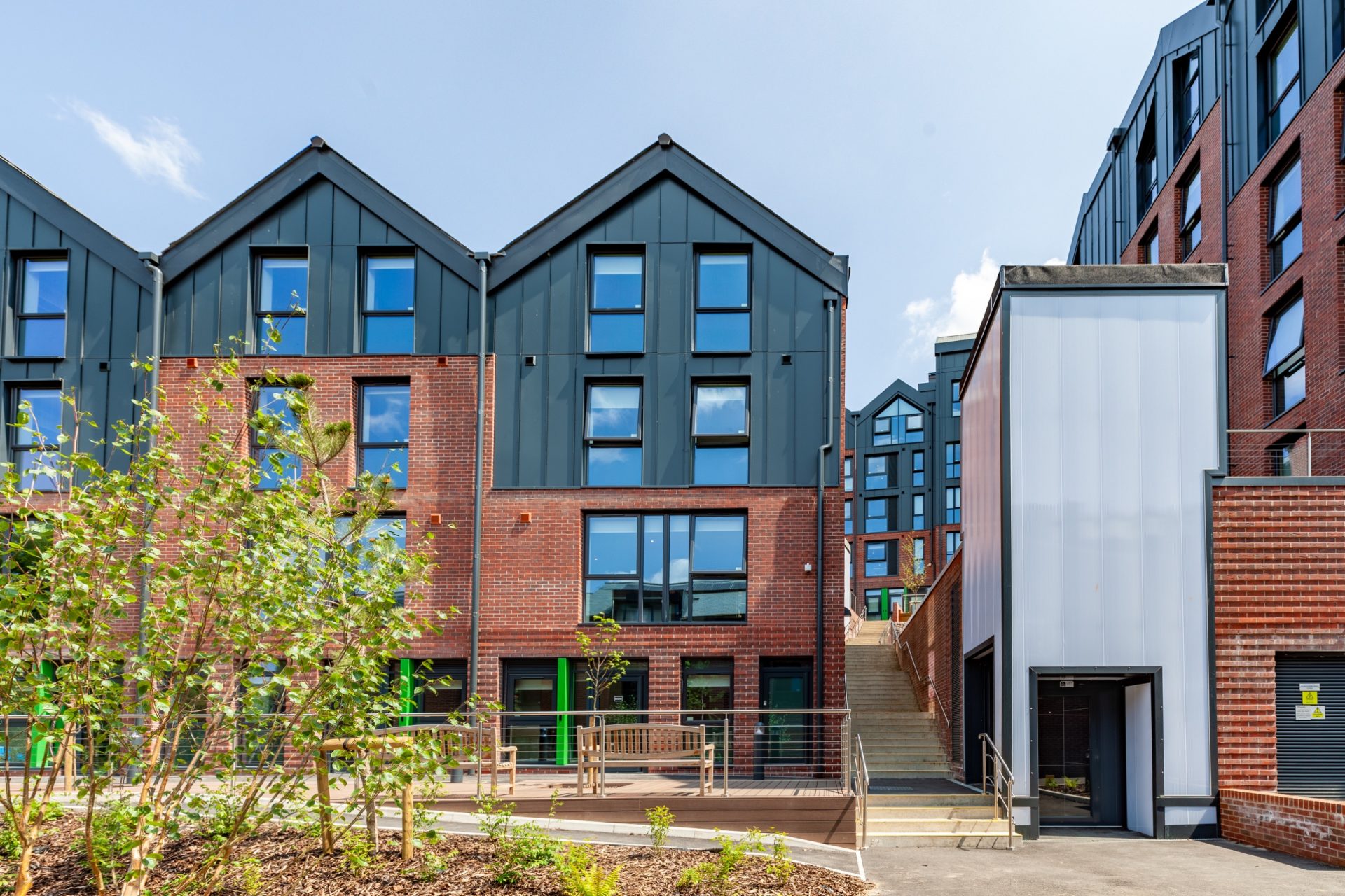 Exterior of Hill View Place student accommodation, with modern brick and dark-clad buildings and landscaped grounds.