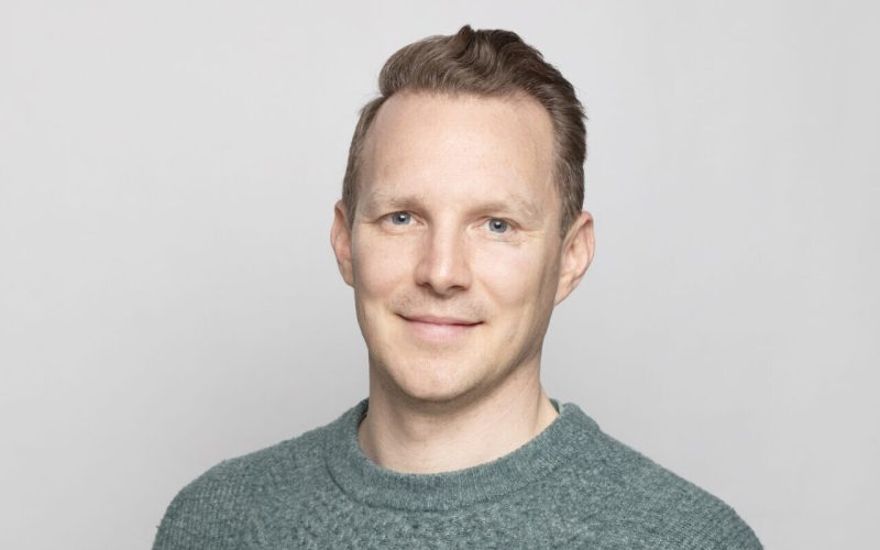 A man wearing a light green jumper