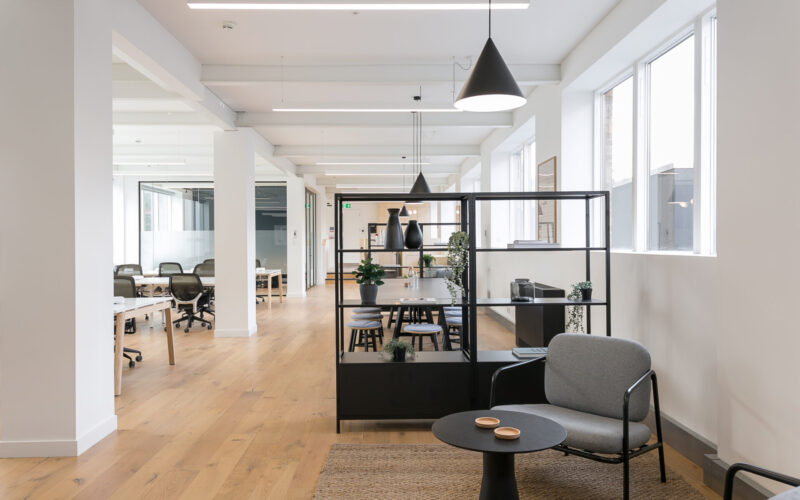 Interior of a modern office featuring white walls and pillars and wooden floors