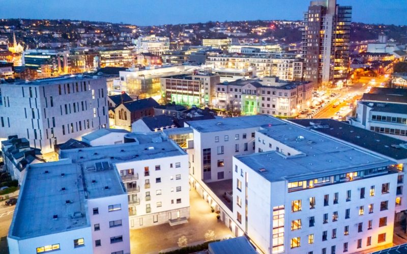 Aerial view of a city at dusk featuring lots of different sized buildings