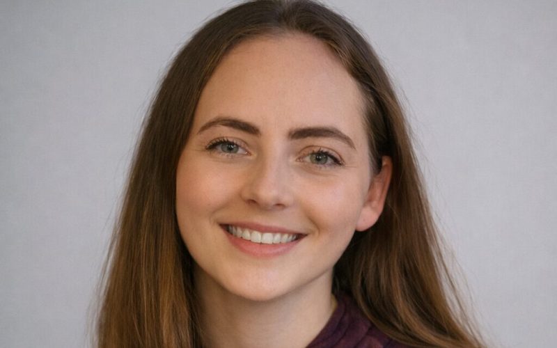 A smiling young woman with long brown hair