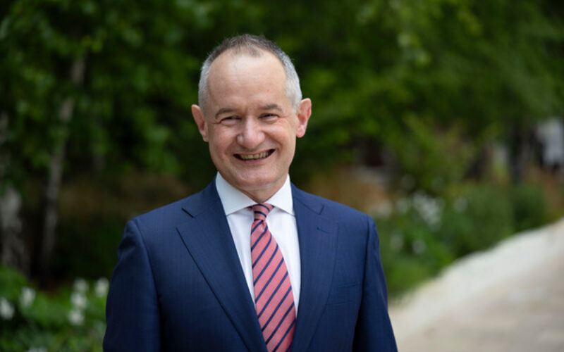 David Allen Mace CFO wearing a dark blue suit, a blue shirt and a red tie