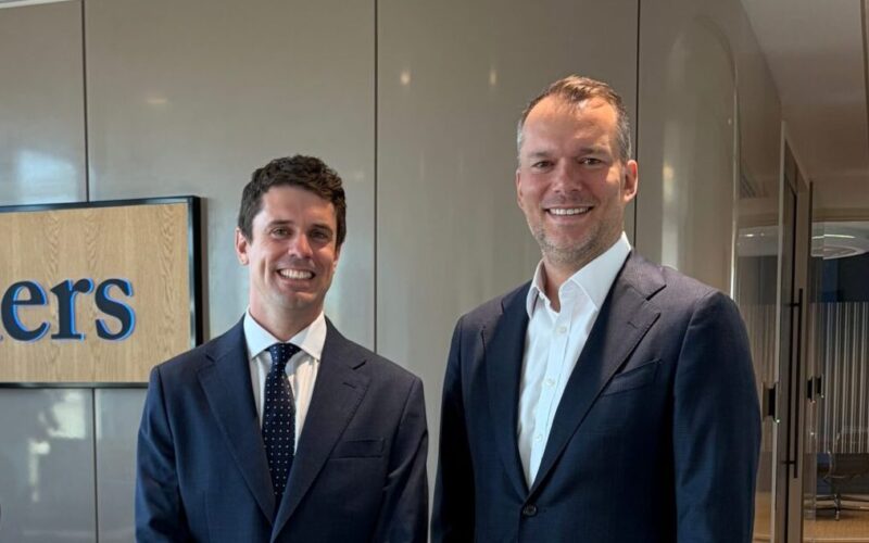 Two smiling men wearing suits