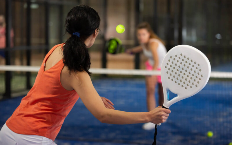 Rear,View,Of,Brunette,Girl,With,White,Racket,Playing,Padel