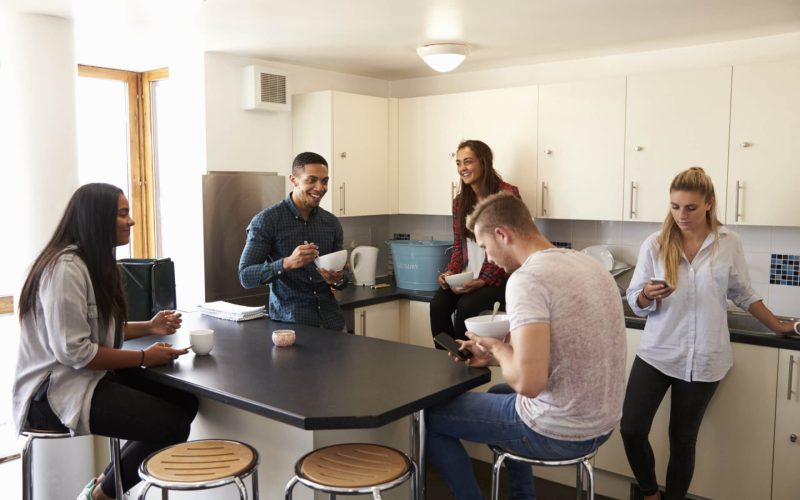 Students,Relaxing,In,Kitchen,Of,Shared,Accommodation