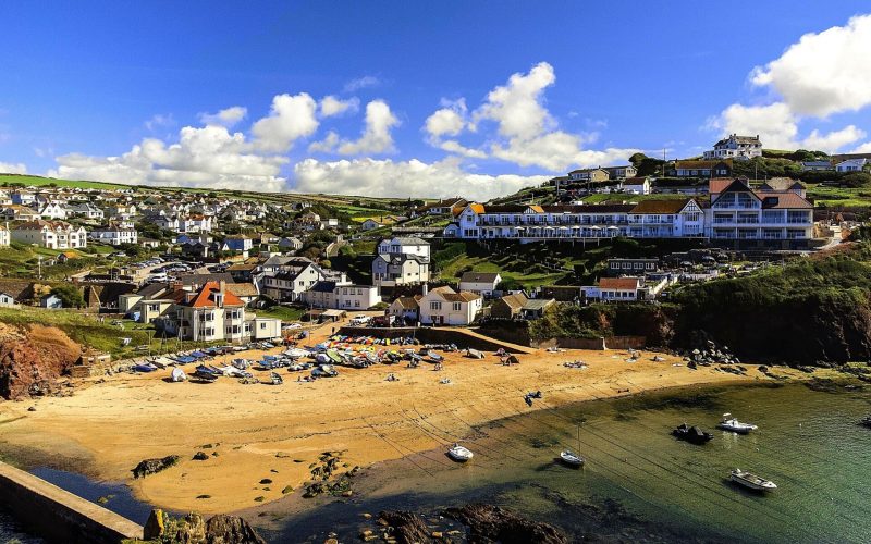 A bay in South Devon with the beach and sea in the foreground and buildings on the hillside