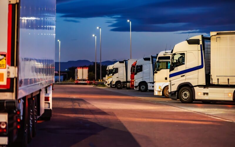 Several,Trucks,Parked,In,A,Motorway,Car,Park,At,Night,