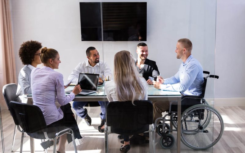 Disabled,Male,Manager,Sitting,With,His,Colleagues,At,Workplace