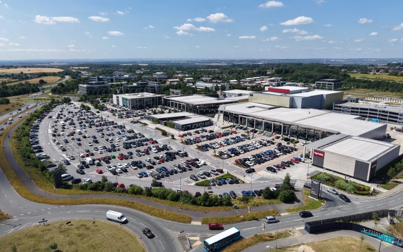 Aerial view of The Springs retail park in Leeds, with its shops, parking lots and surrounding roads.