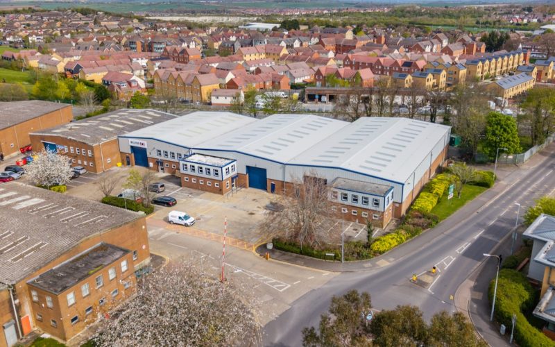 Aerial view of modern industrial units beside a road and residential neighbourhood