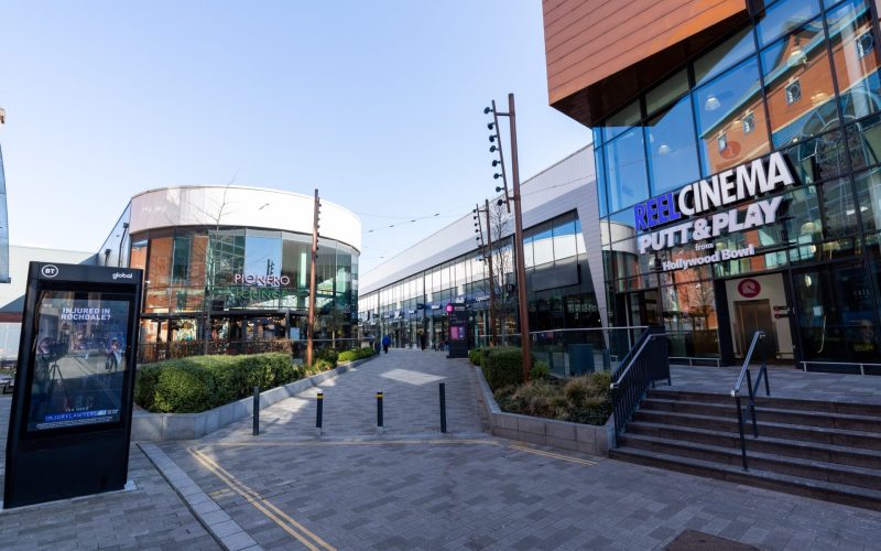 Rochdale Riverside shopping centre walkway with the Real Cinema entrance, retail units and pedestrians