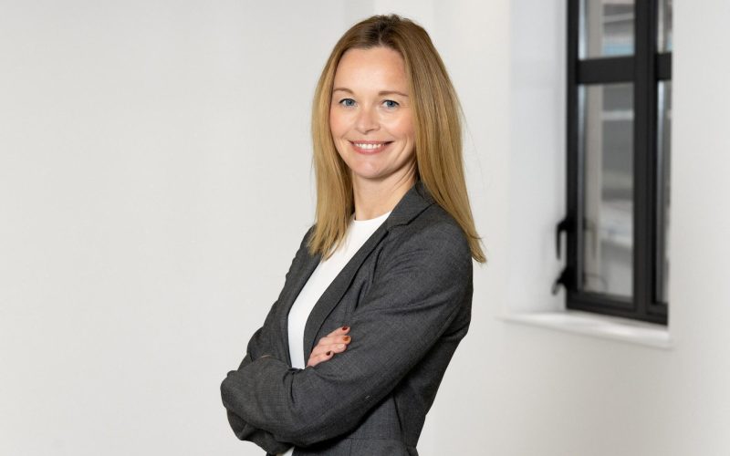 Real estate partner Rachel Kerr stands with her arms crossed in a dark blazer.