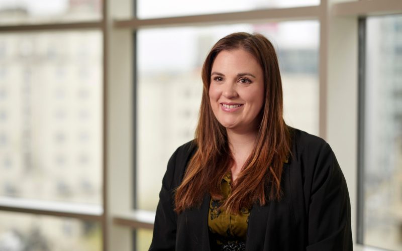 Jennifer Pearson, a property litigation solicitor, smiles at the camera in a black blazer and olive blouse.