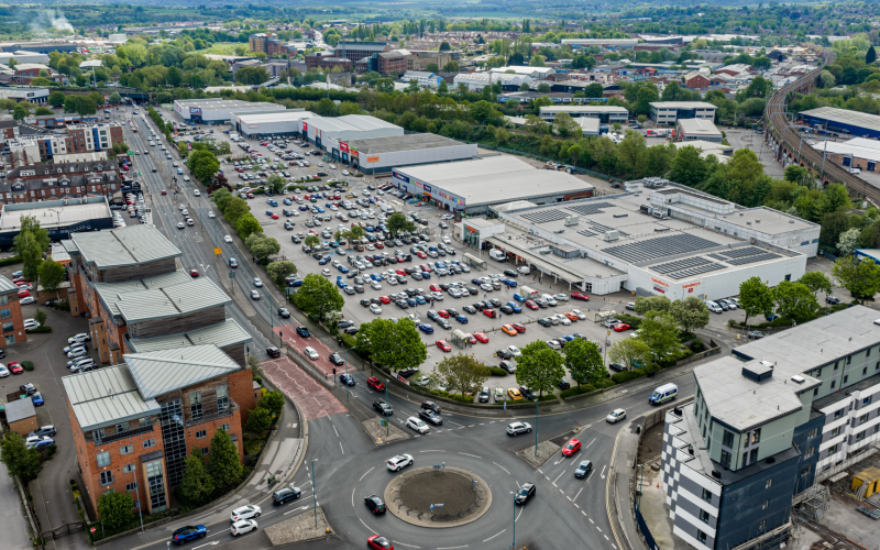 Aerial view of Beck Retail Park in Wakefield, with rows of retail units, car parks and surrounding roads.
