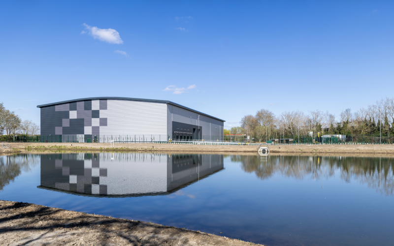 AIR Industrial Estate in Heathrow, a modern logistics building reflected in a pond.