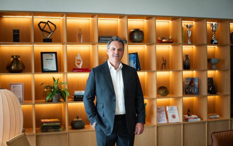 Montagu Evans managing partner Alan Harris stands in front of a display of office shelves.