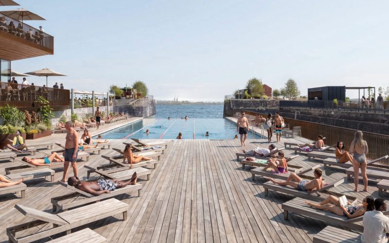 People relaxing beside a large outdoor pool on a waterfront leisure deck