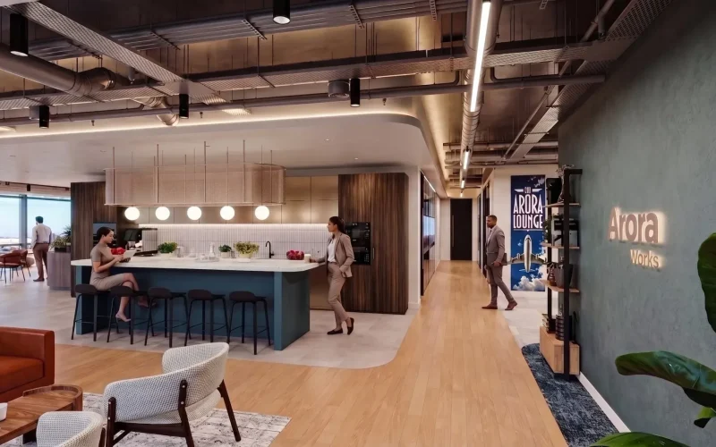 Arora Works flexible workspace interior with people in a communal kitchen and lounge area.