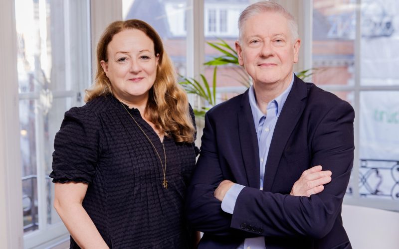 Tandem Property co-CEOs Lisa Riva and John Jones pose together indoors.