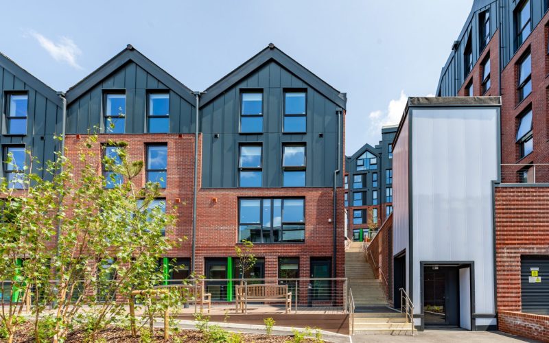 Exterior of Hill View Place student accommodation, with modern brick and dark-clad buildings and landscaped grounds.