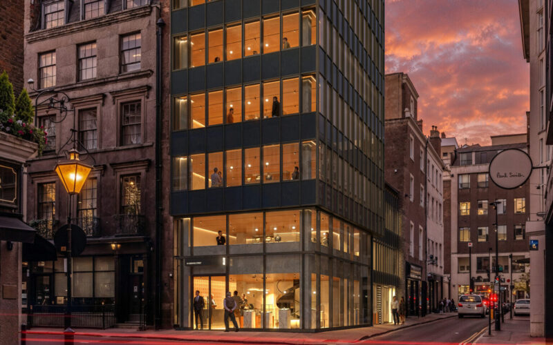 CGI of a corner office building with lots of windows on the front and the side pictured at dusk