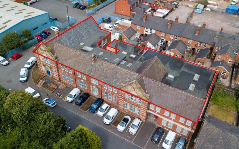 Aerial view of a brick built Victorian building with a red line highlighting the extent of the site