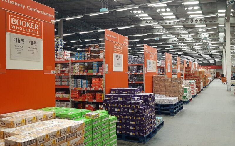 Interior of a Booker wholesale unit featuring lots of food products stacked on shelves and pallets