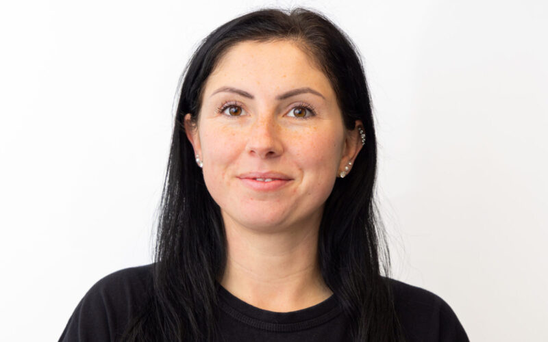 A woman with long dark hair wearing a dark shirt