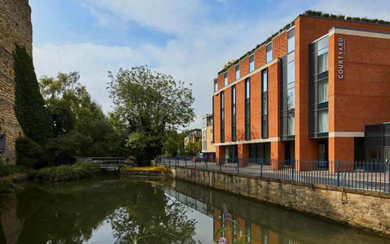 The Courtyard by Marriott hotel in Oxford city centre is a brown brick building located next to a river