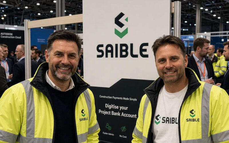 Two mean wearing high vis jackets in front of a Saible sign