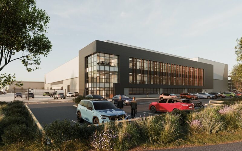 Modern logistics building with windows lining the facade and car parking and planting to the front of the scheme