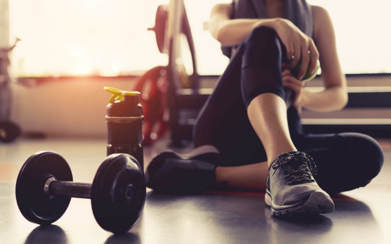 Woman,Exercise,Workout,In,Gym,Fitness,Breaking,Relax,Holding,Apple