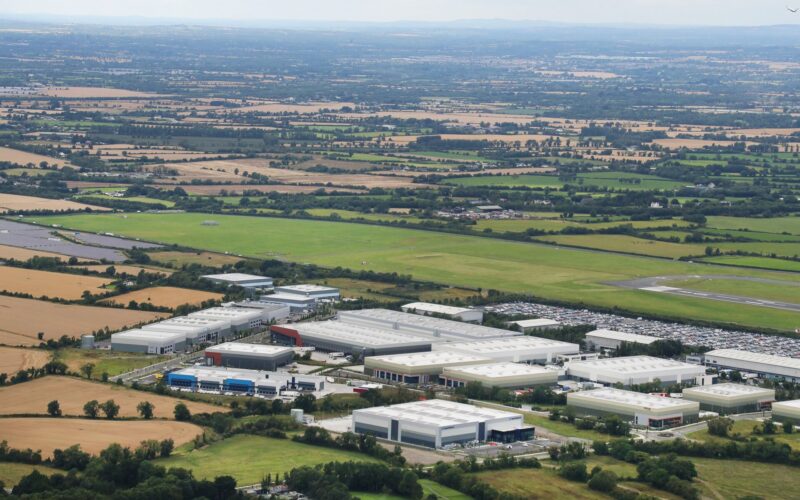 Aerial view of a series of industrial buildings surrounded by green fields