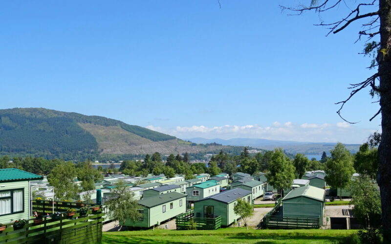A caravan park with hills and greenery in the background